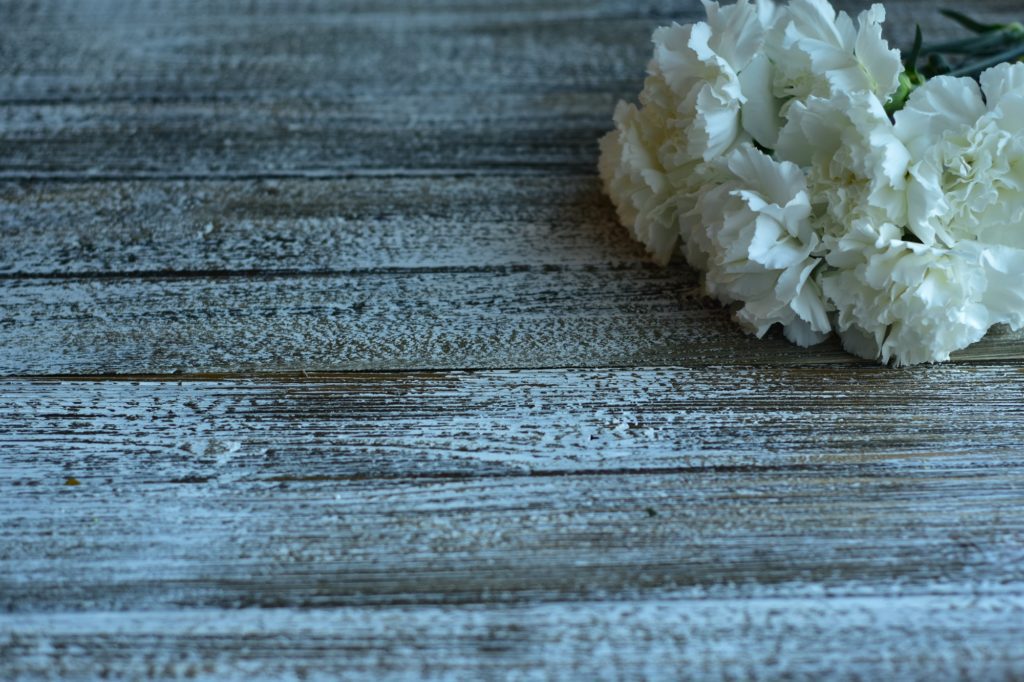 white carnations on a wooden table