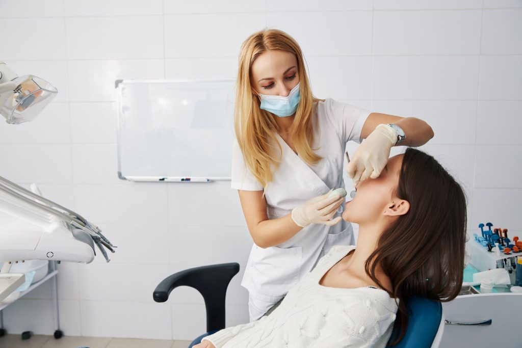 Dentist placing putty patient mouth for